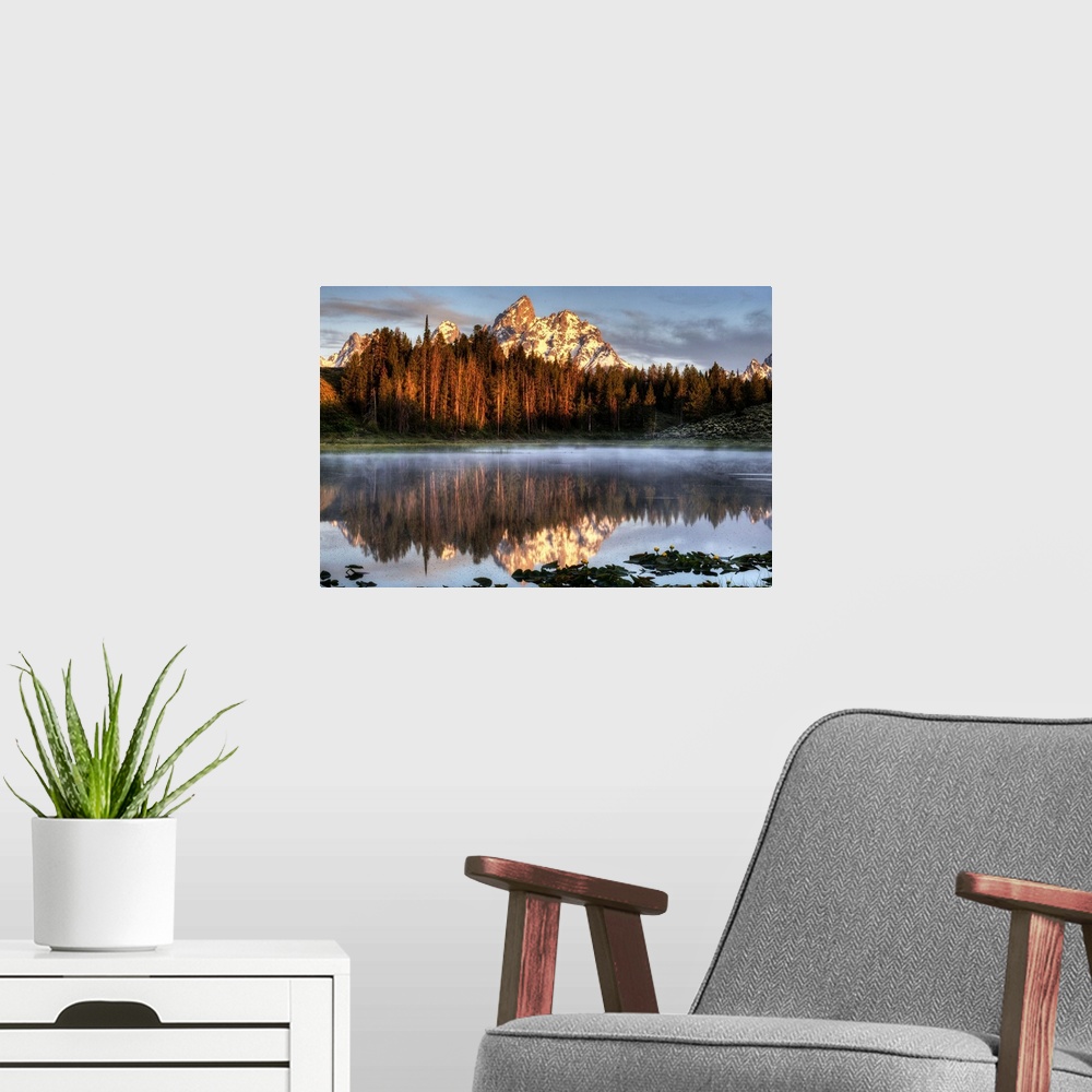A modern room featuring An image of the Grand Tetons at sunrise.