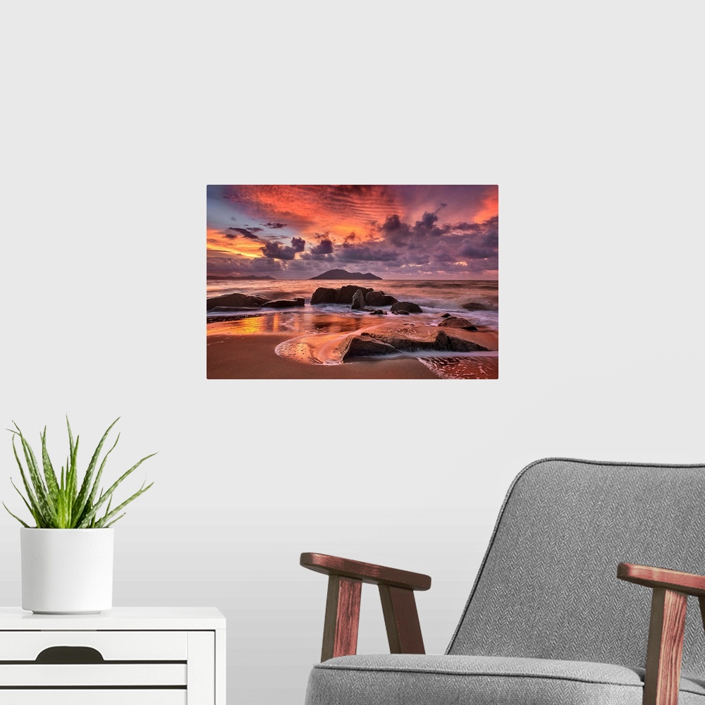 A modern room featuring Rocky beach at sunset, with dramatic clouds looming in the distance.
