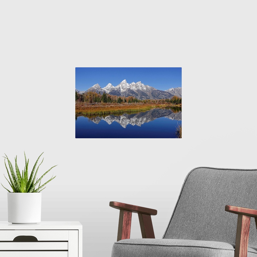 A modern room featuring The Grand Tetons reflected on the Snake river near Jackson, Wyoming.