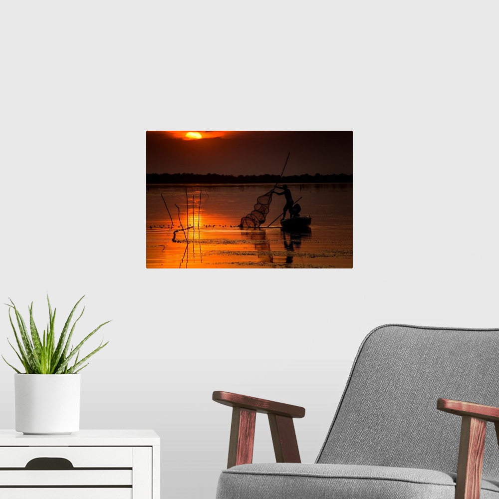 A modern room featuring A fisherman from Danube Delta, Romania at sunset.
