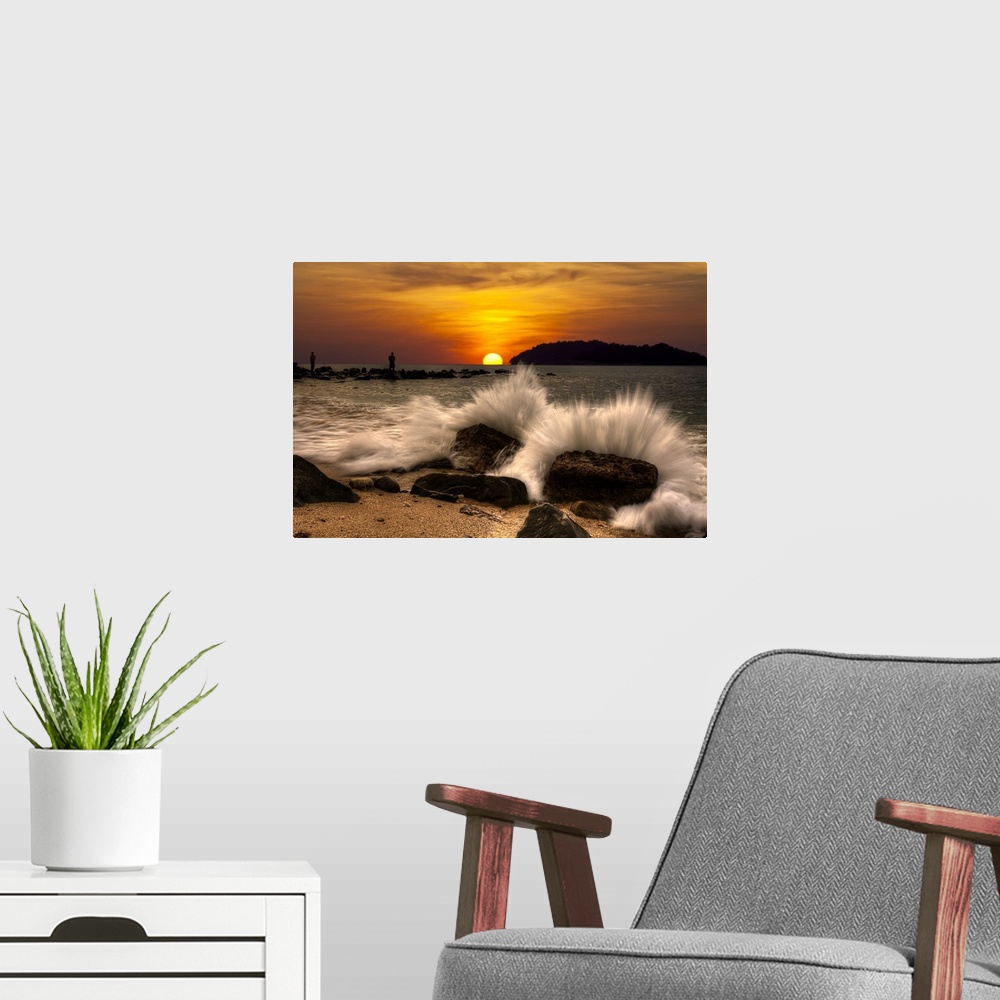 A modern room featuring Waves crashing onto rocks on the beach at sunset.