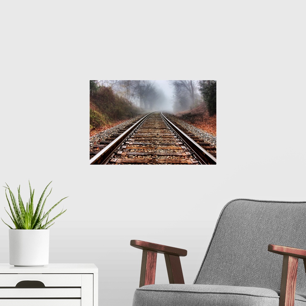 A modern room featuring Railroad tracks leading into the fog in the morning.