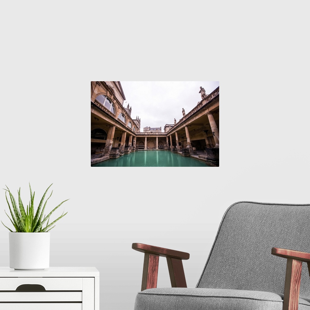 A modern room featuring Photograph of the Great Bath in England with gray, cloudy skies above, Bath, England, UK