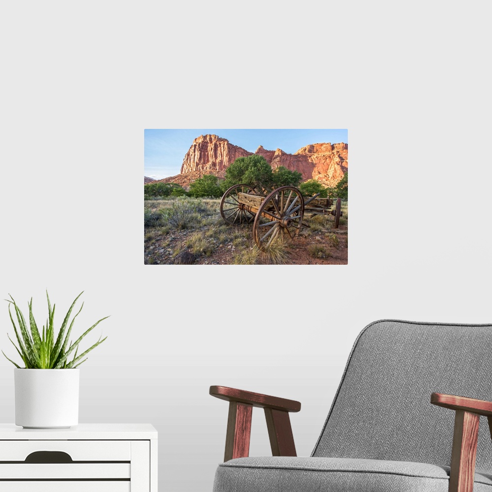 A modern room featuring An antique wagon under Fruita's rock formations in Capitol Reef National Park, Utah.