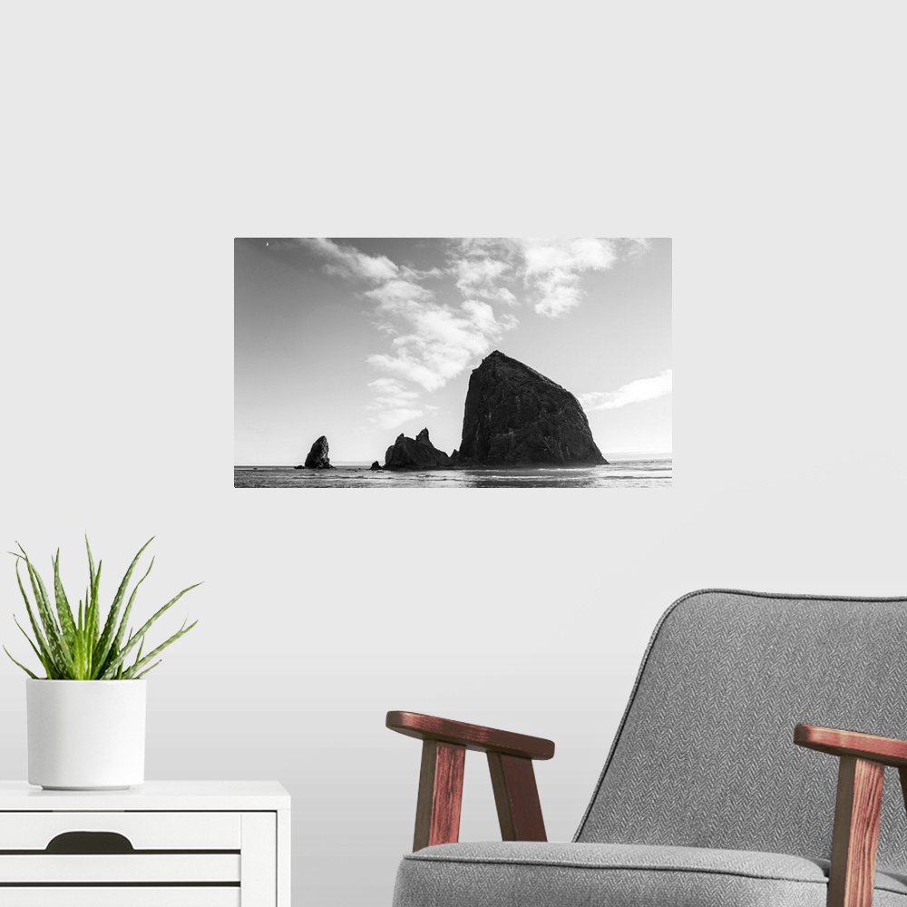 A modern room featuring Black and white photograph of Haystack Rock with the moon in the top corner.