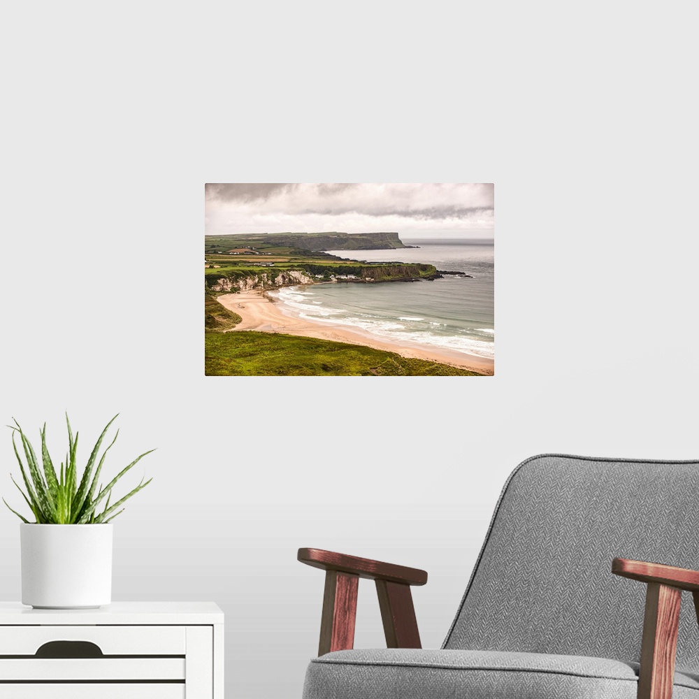 A modern room featuring Landscape photograph of an Irish coastline with dramatic clouds above, County Antrim, Ireland.