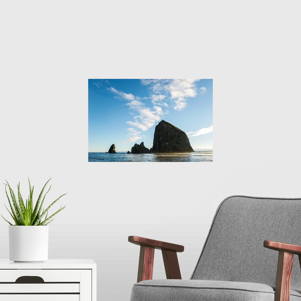A modern room featuring Photograph of Haystack Rock with the golden sun shining on its side and the moon in the top corner.