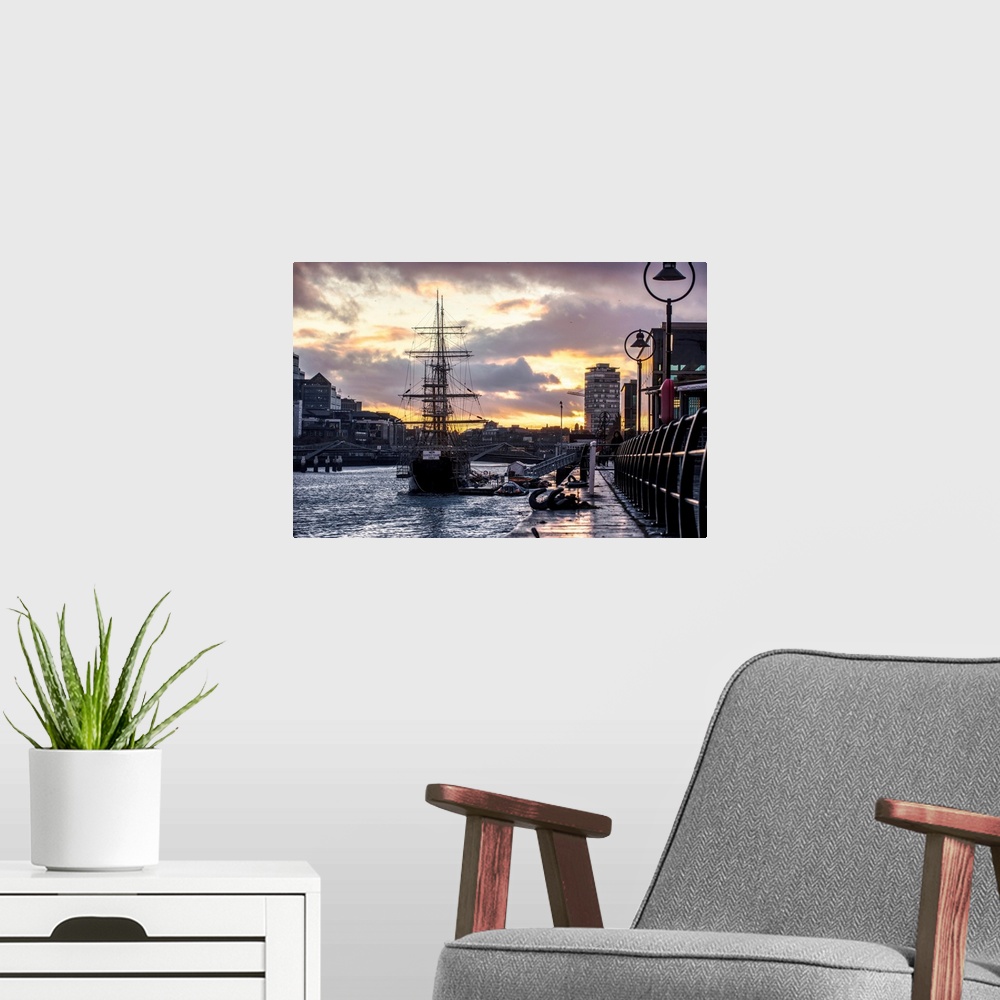 A modern room featuring View of Jeanie Johnston tall ship docked in Dublin, Ireland as the sun is setting.
