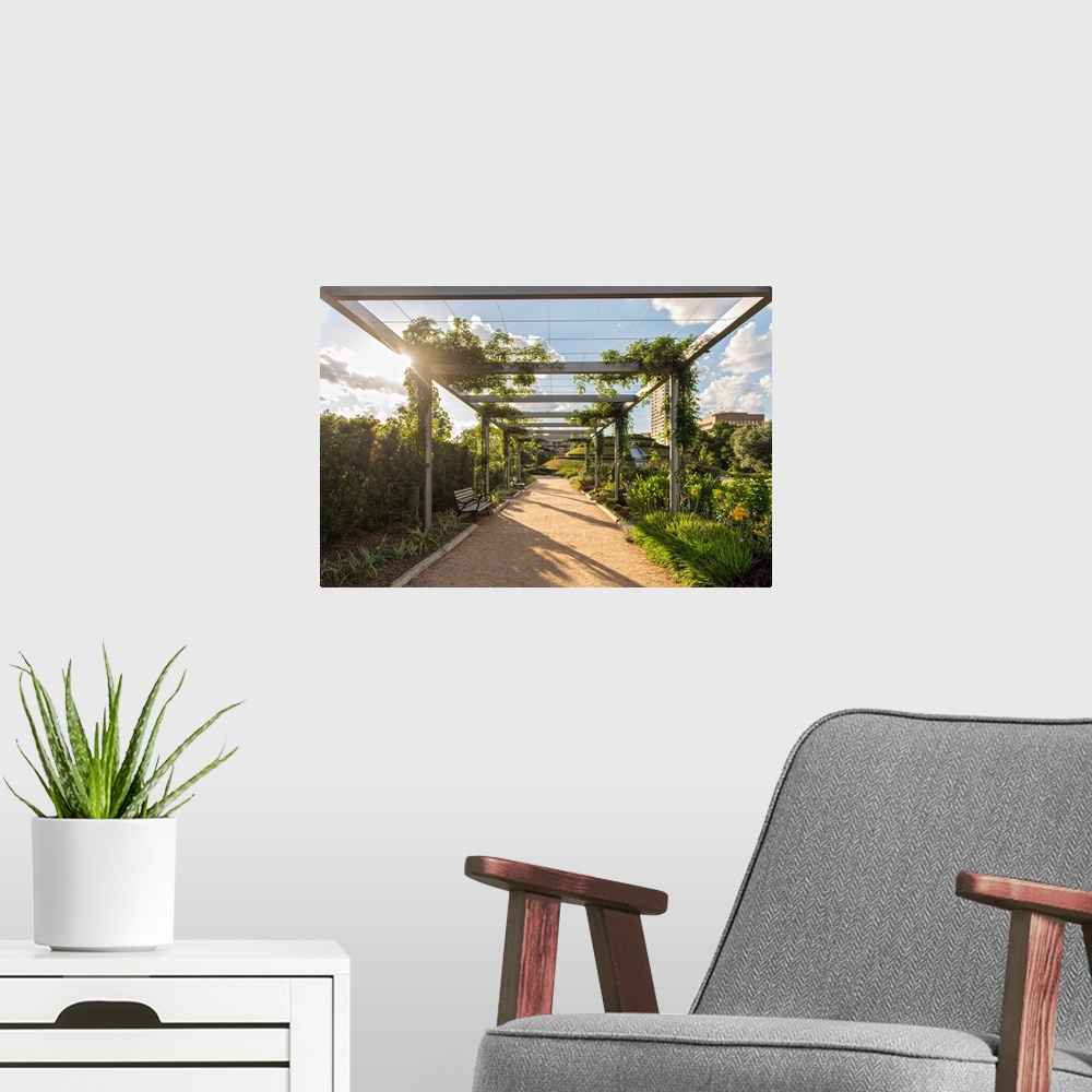 A modern room featuring Dirt path lined with beautiful plants and flowers under a pergola in McGovern Centennial Gardens ...