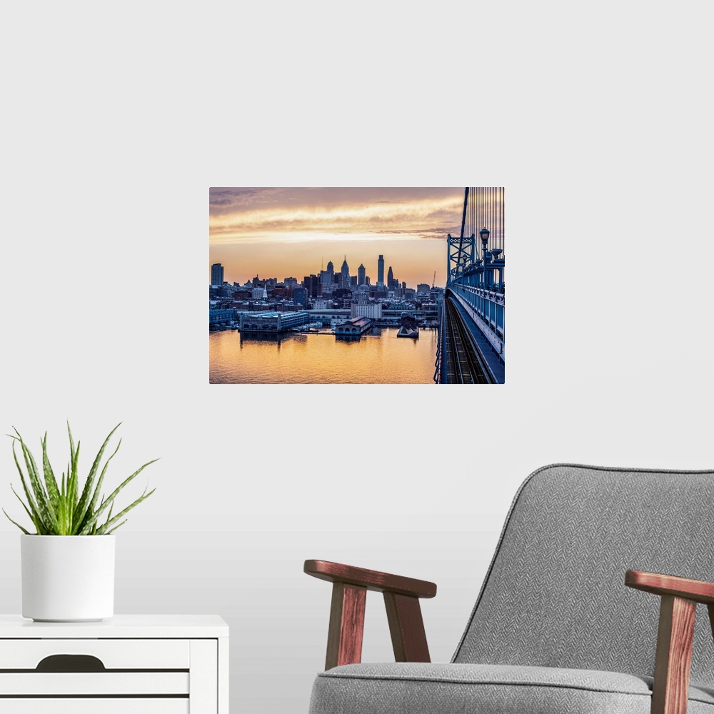 A modern room featuring View of Philadelphia's city skyline against a dewy melon colored sky.