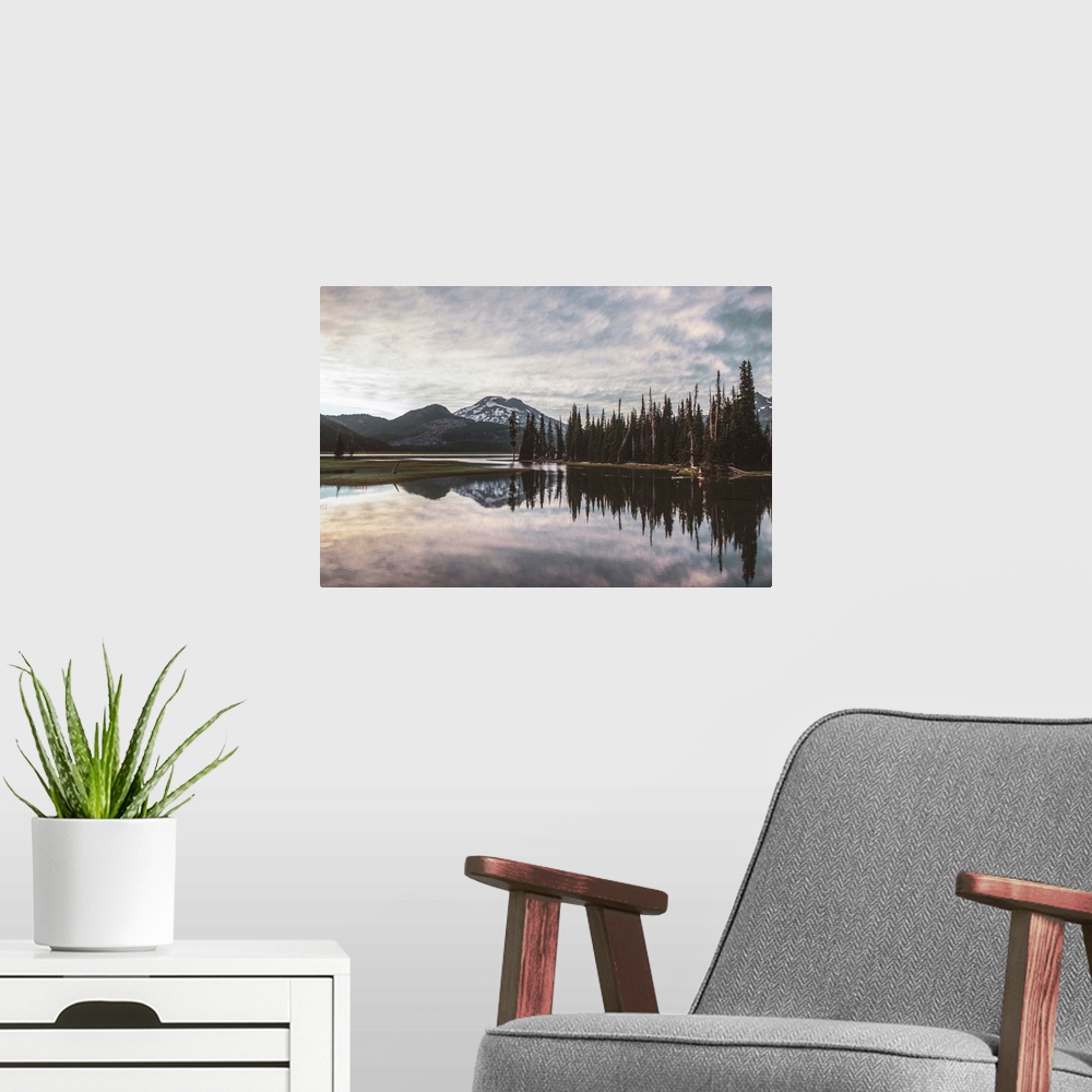 A modern room featuring View of trees reflecting in Sparks Lake on a cloudy day in Deschutes National Forest, Oregon.