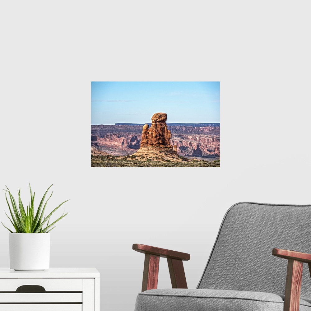 A modern room featuring Sandstone tower overlooking the canyon and desert under a pale blue sky in Arches National Park, ...