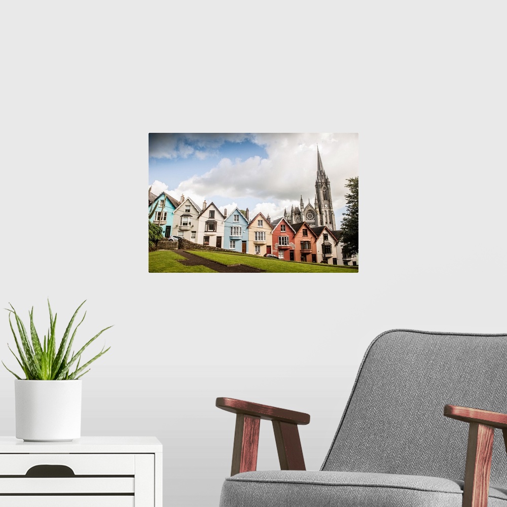 A modern room featuring Colorful facades from a row of houses in the Old Town, with St. Colman's cathedral in the backgro...