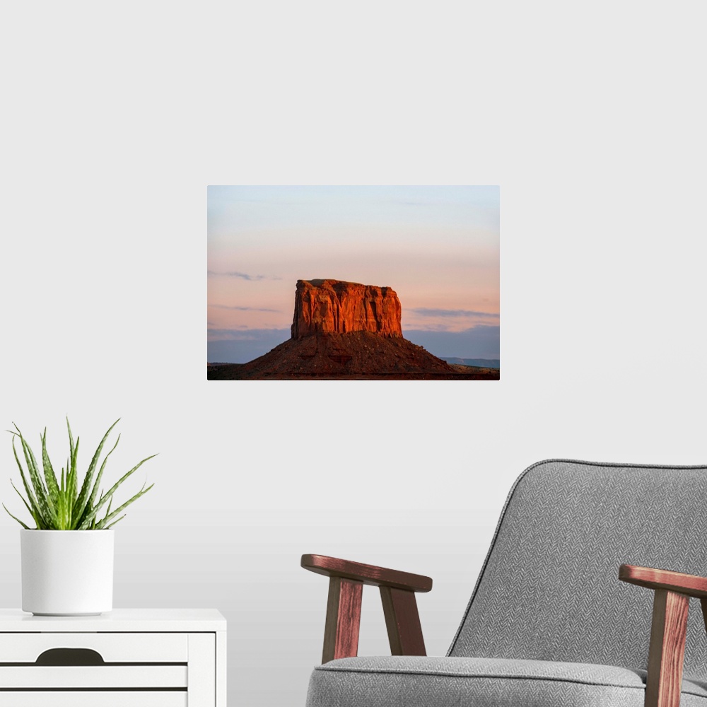 A modern room featuring The sun sets on Mitchell Butte, highlighting the rich red sandstone In Monument Valley, Arizona.