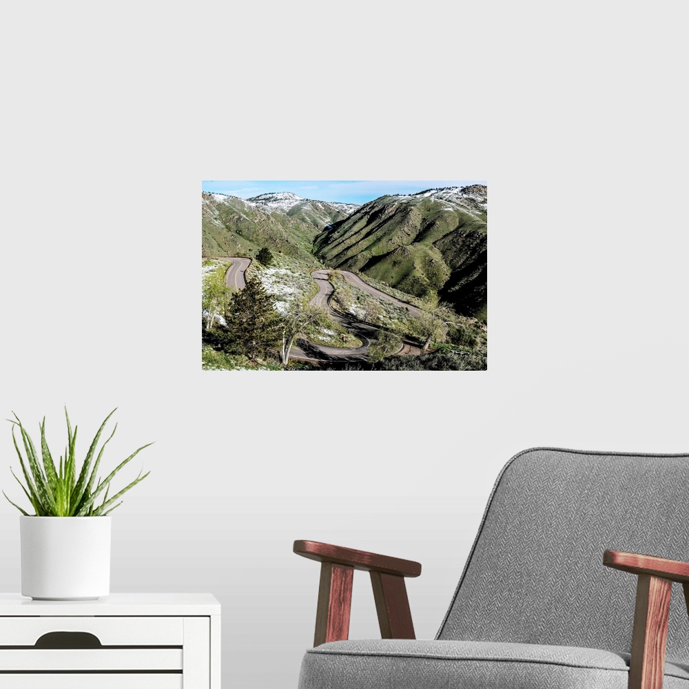 A modern room featuring Photo of a winding road below a mountain slightly covered in snow in Colorado.