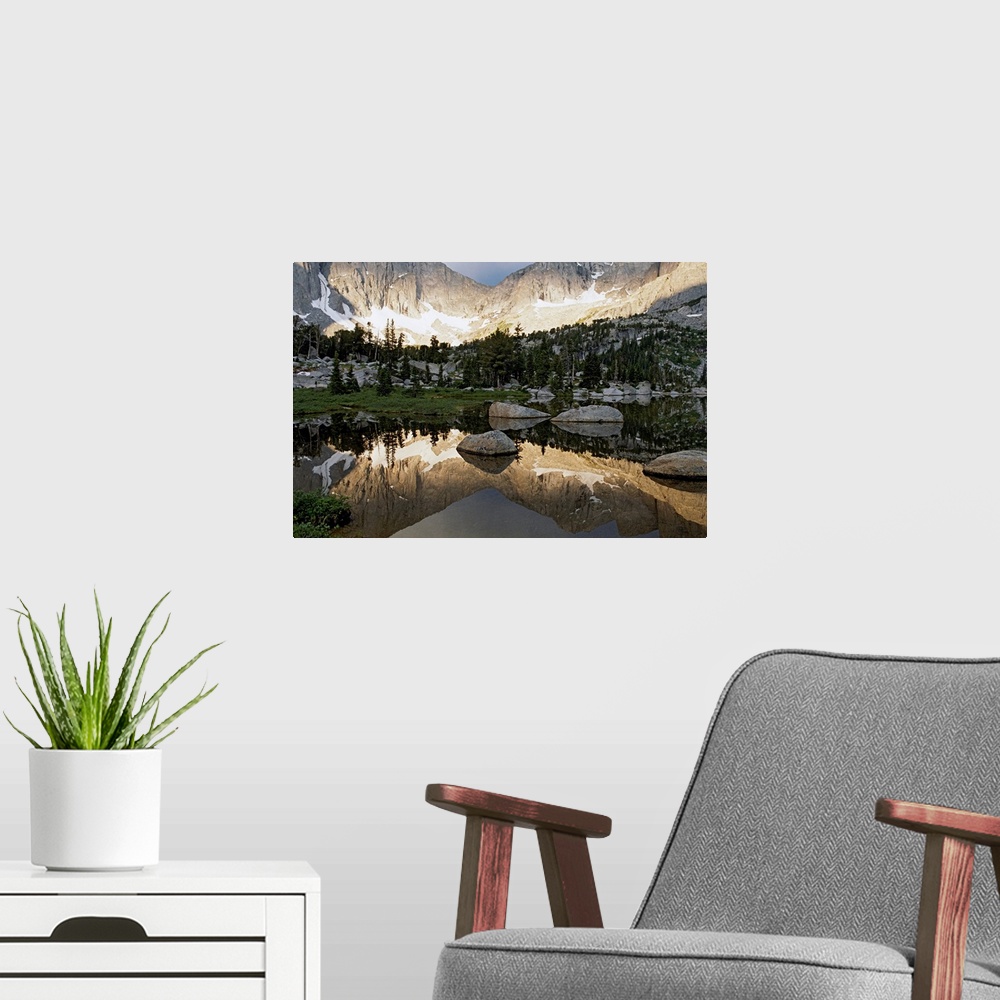 A modern room featuring From the National Geographic Collection, a large photograph focuses on a small body of water refl...