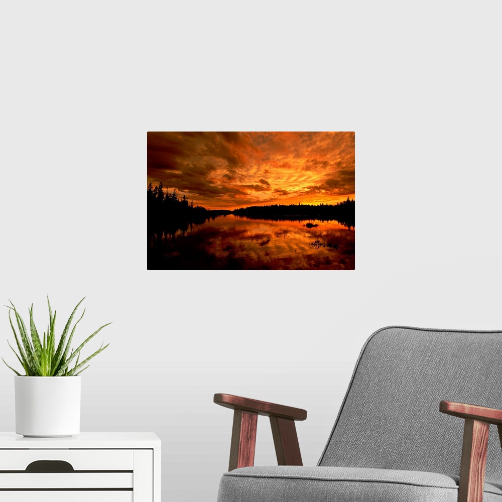 A modern room featuring Horizontal photograph from the National Geographic Collection of a golden sunset over a lake, und...