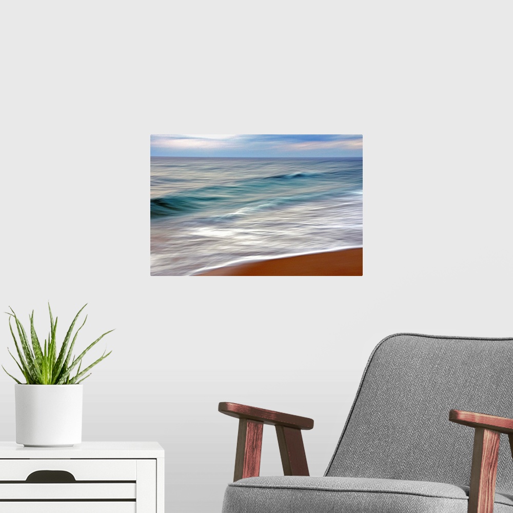 A modern room featuring Giant horizontal photograph from the National Geographic Collection of small blue waves reaching ...