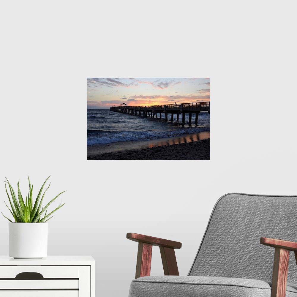 A modern room featuring The sun rises over an Atlantic Ocean pier.