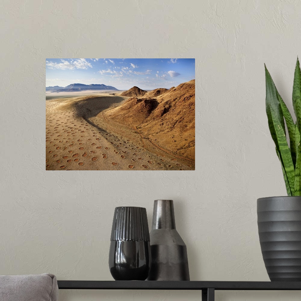 A modern room featuring Aerial view from hot air balloon over magnificent desert landscape of sand dunes, mountains and F...