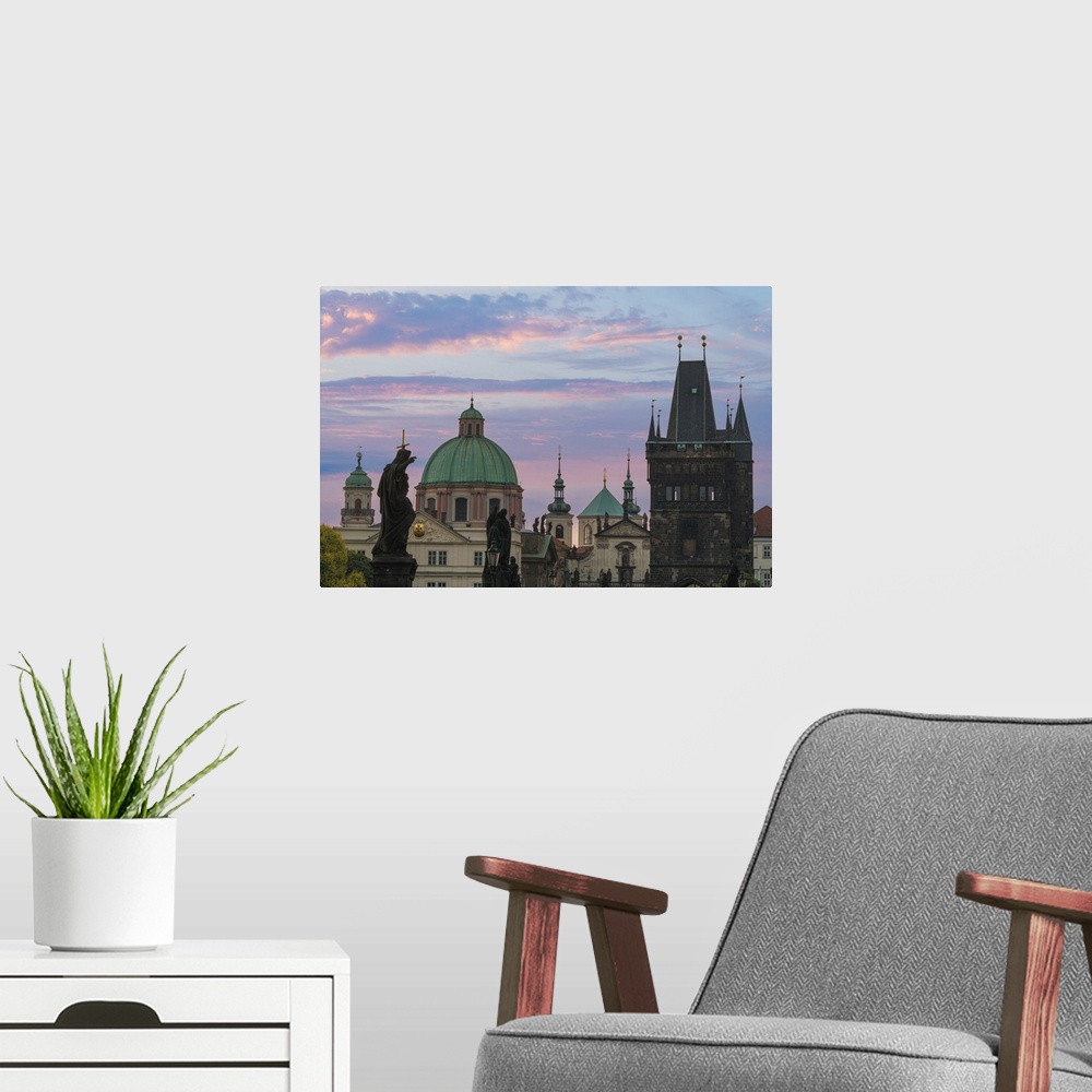 A modern room featuring Details of statues and spires at Charles Bridge at sunrise, featuring dome of Church of Saint Fra...