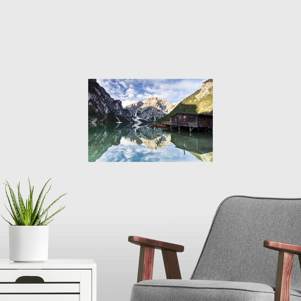 A modern room featuring Lake Braies (Pragser Wildsee) at sunrise with Croda del Becco mountain reflected in water, Dolomi...