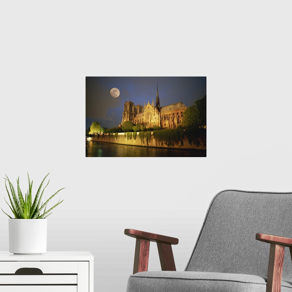 A modern room featuring Notre Dame Cathedral at night, with moon rising above, Paris, France, Europe