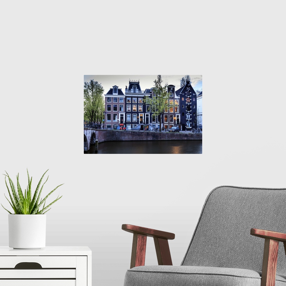 A modern room featuring Old gabled houses line the Keizersgracht canal at dusk, Amsterdam, Netherlands, Europe.