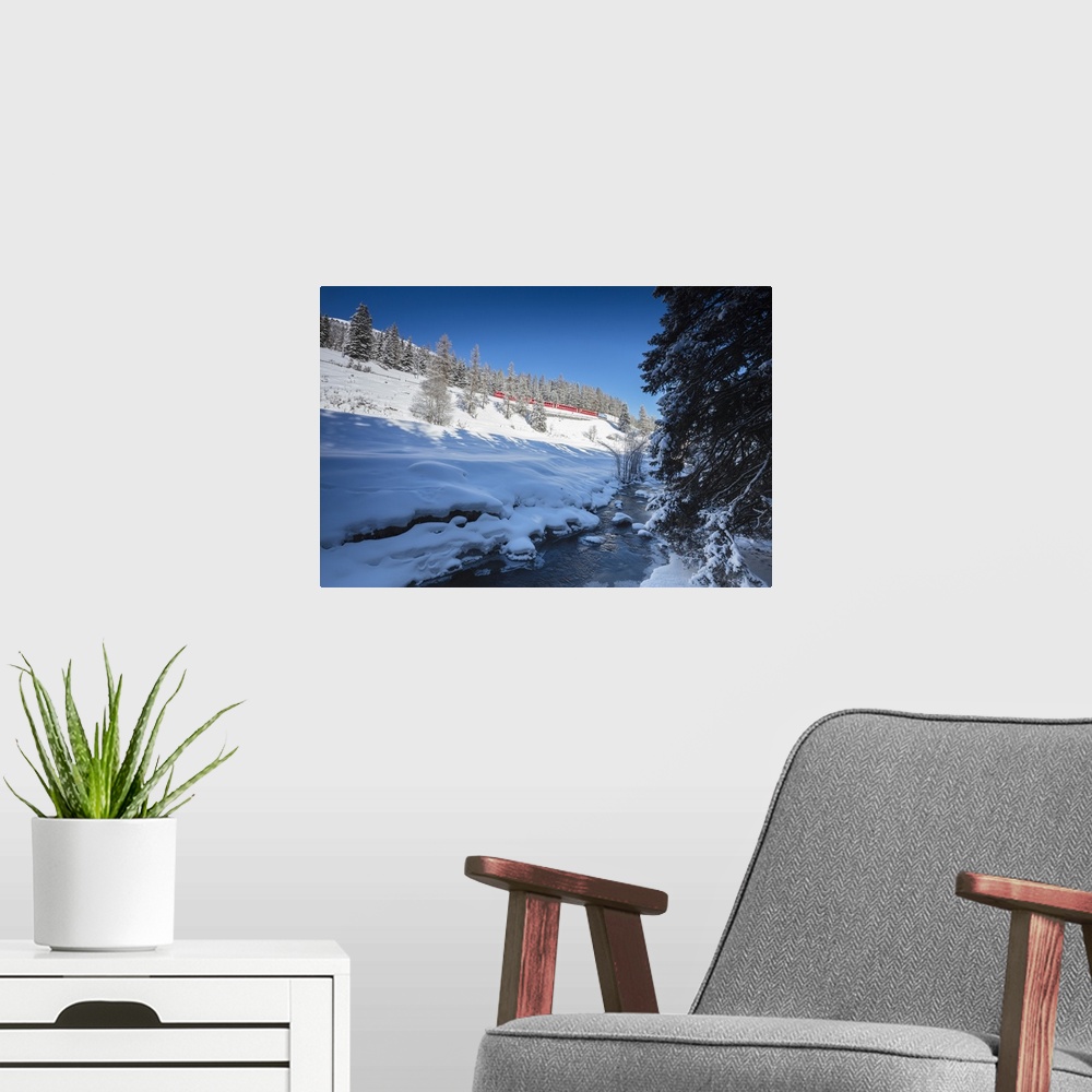 A modern room featuring Rhaetian Railway on the Chapella Viadukt surrounded by snowy woods, Canton of Graubunde, Engadine...