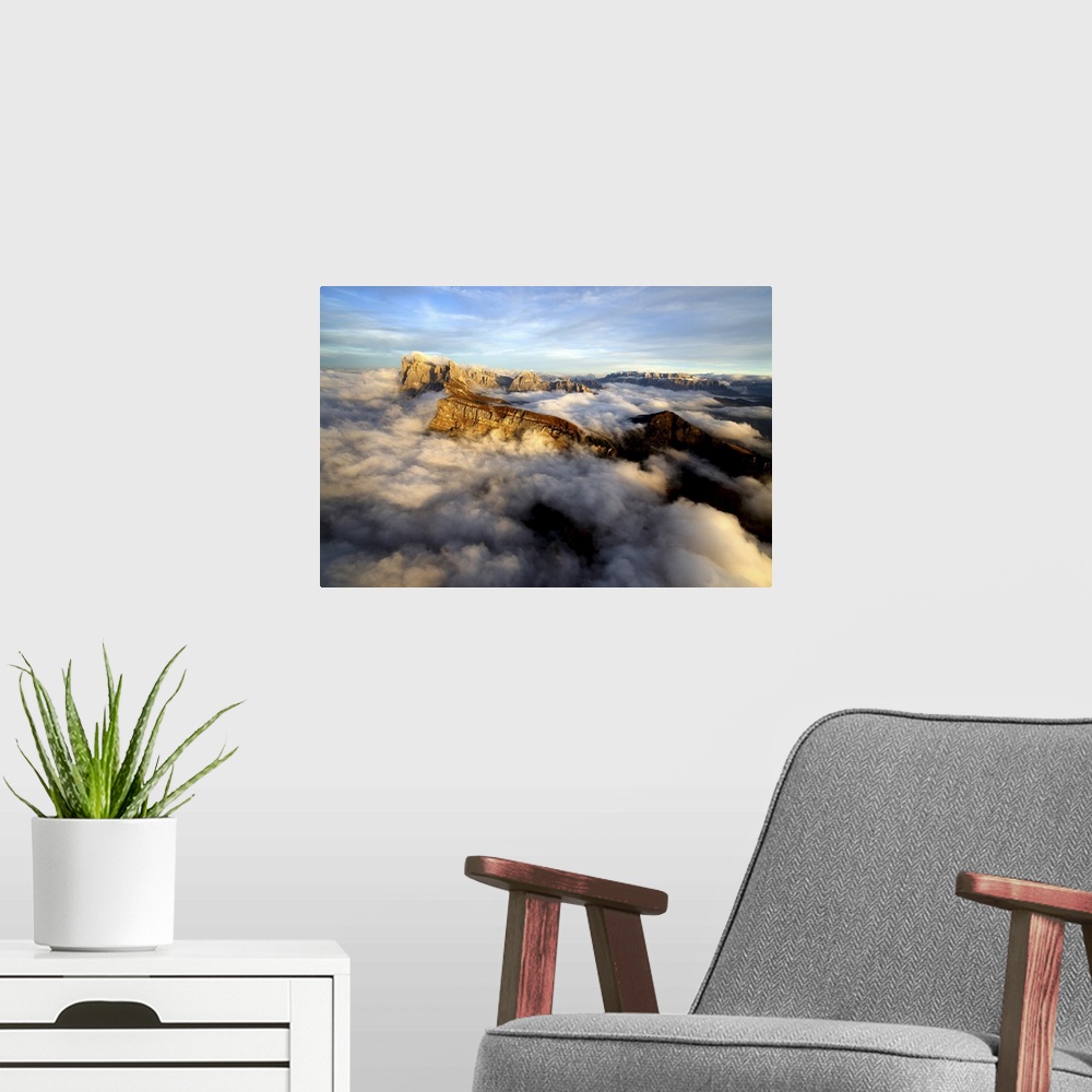 A modern room featuring Aerial shot from Seceda of Odle surrounded by clouds at sunset in the Dolomites, Val Funes, Trent...