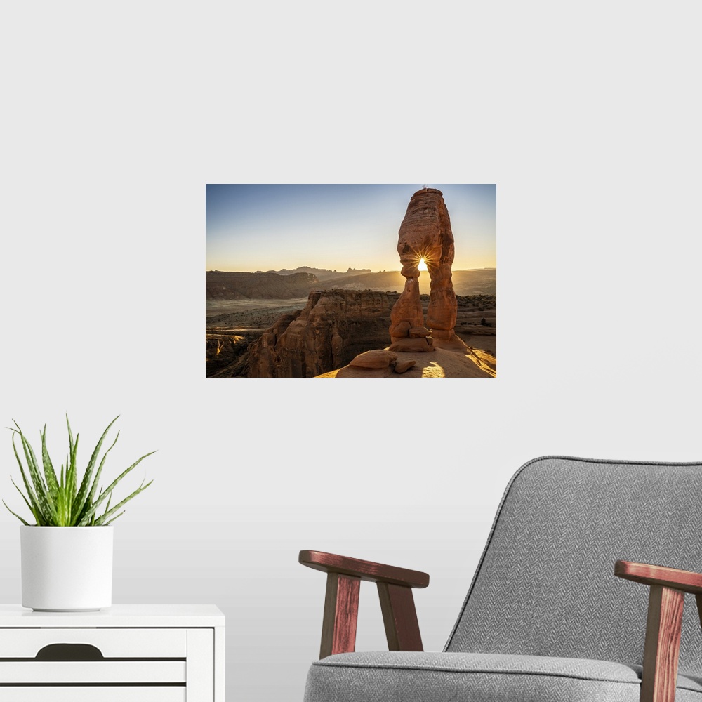 A modern room featuring Setting sun through Delicate Arch with sunburst, Arches National Park, Utah, United States of Ame...