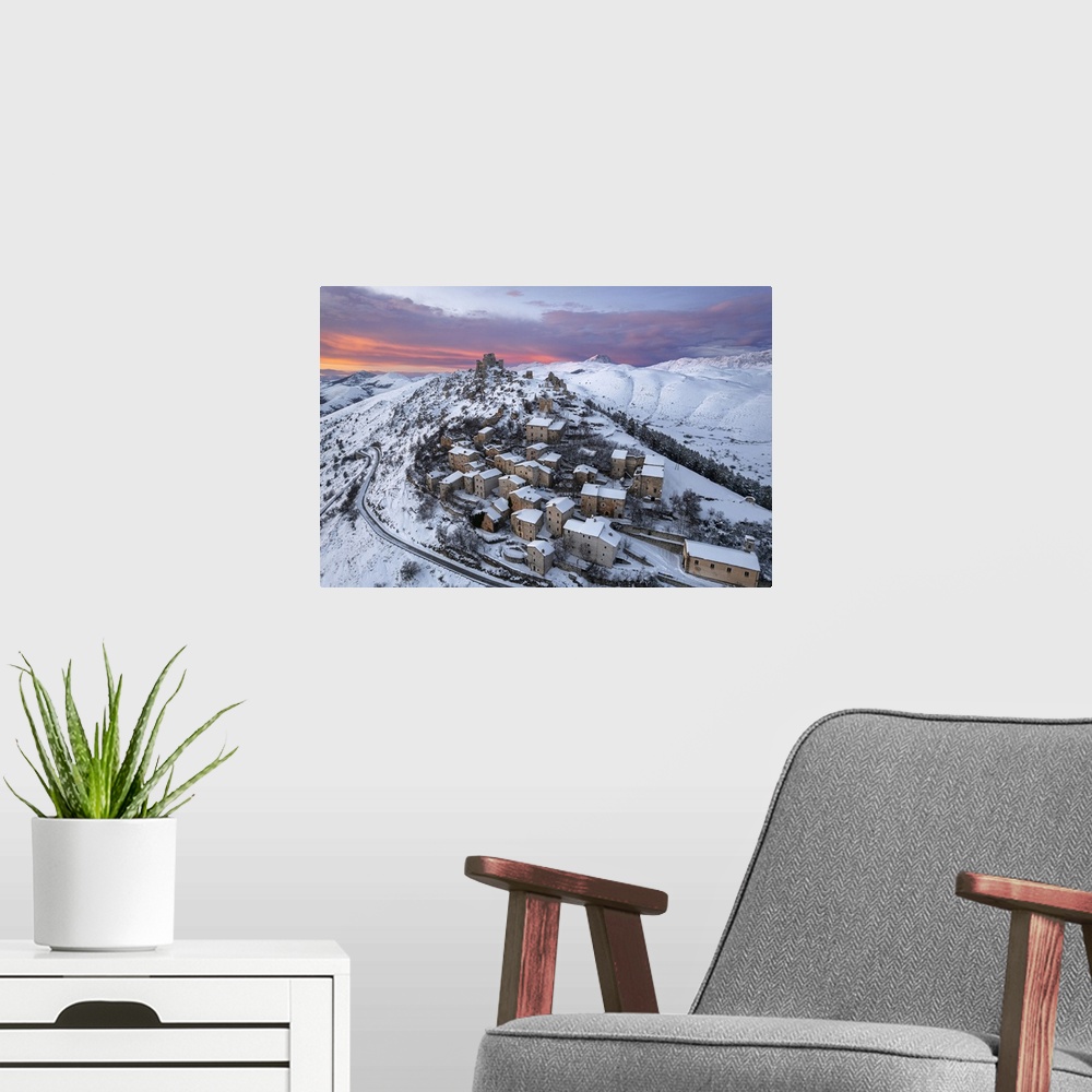 A modern room featuring Aerial winter view of the snow covered medieval village of Rocca Calascio with the castle and pin...