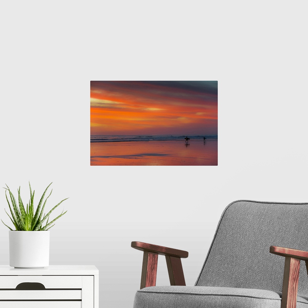 A modern room featuring Surfer silhouetted on Guiones Beach where many come to relax and surf at sunset, Playa Guiones, N...