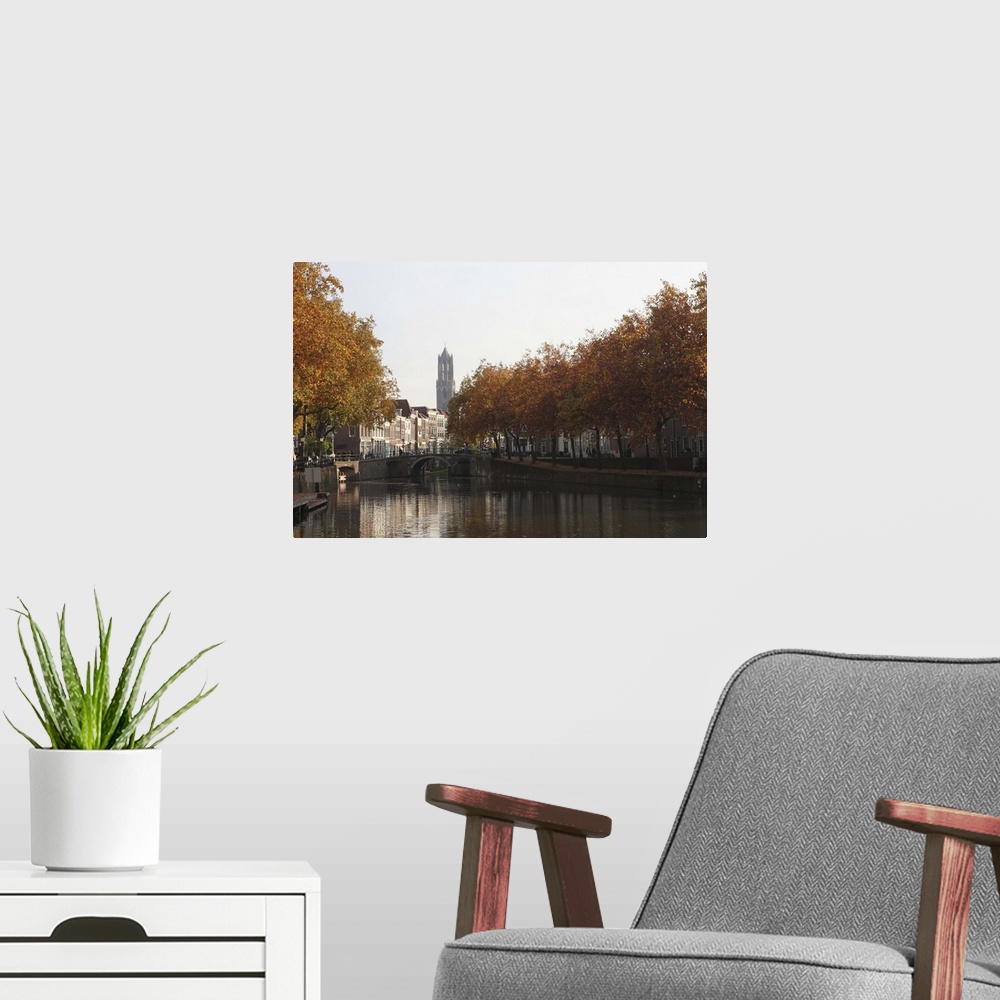 A modern room featuring The Dom Tower and canal waterway on an autumn day, Utrecht, Netherlands