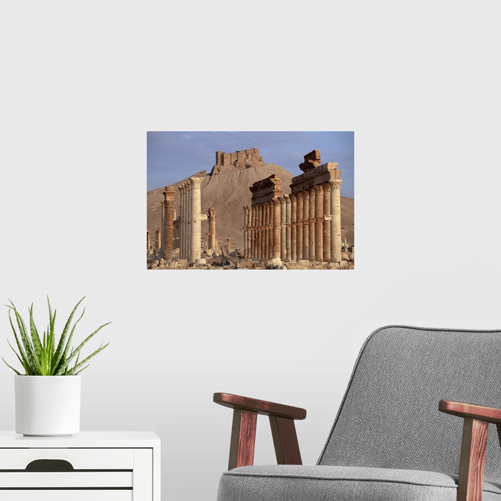 A modern room featuring The Great Colonnade, with Arab castle on hill in background, Palmyra, Syria