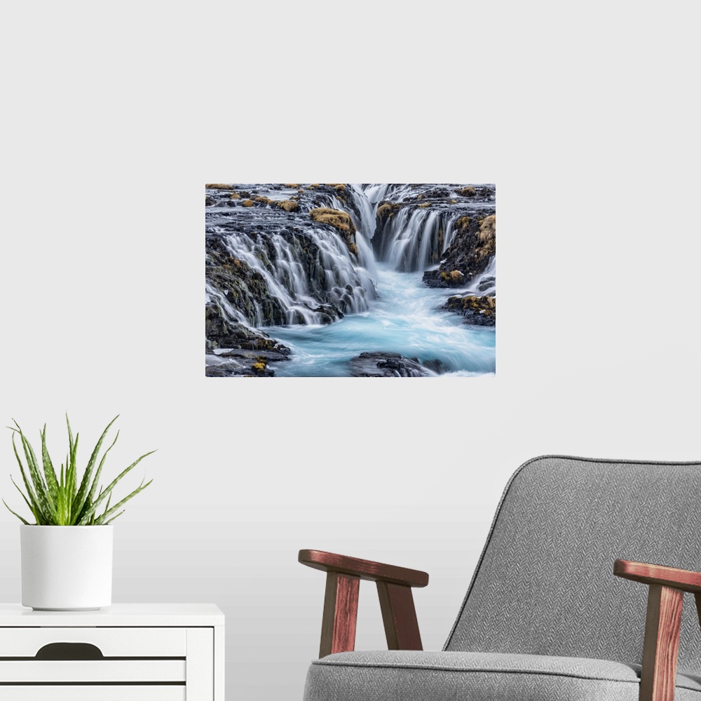 A modern room featuring Bruarfoss waterfall in winter in Iceland.