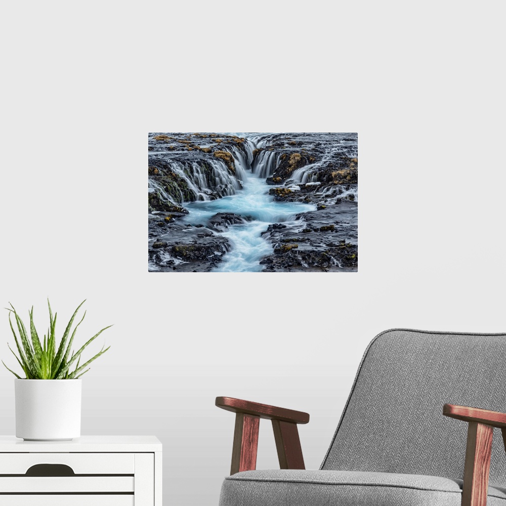 A modern room featuring Bruarfoss waterfall in winter in Iceland.