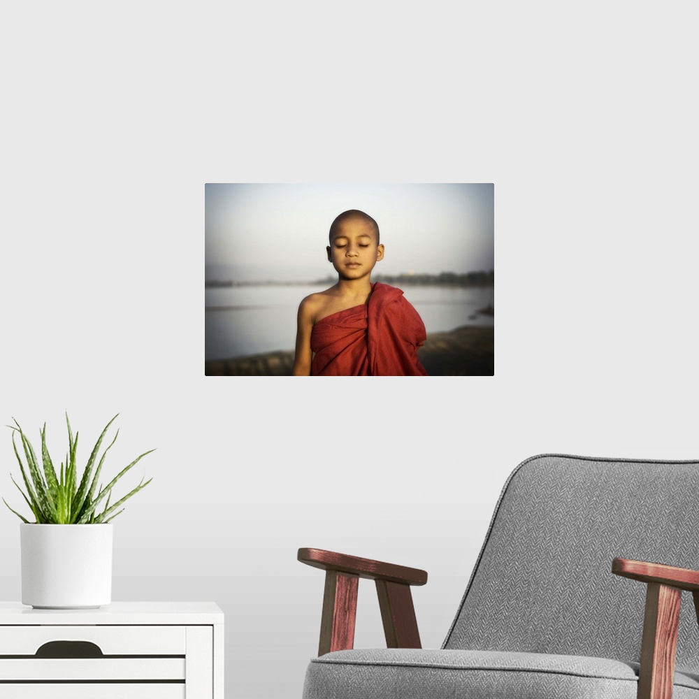 A modern room featuring Young Burmese monk by the water, Mandalay, Burma