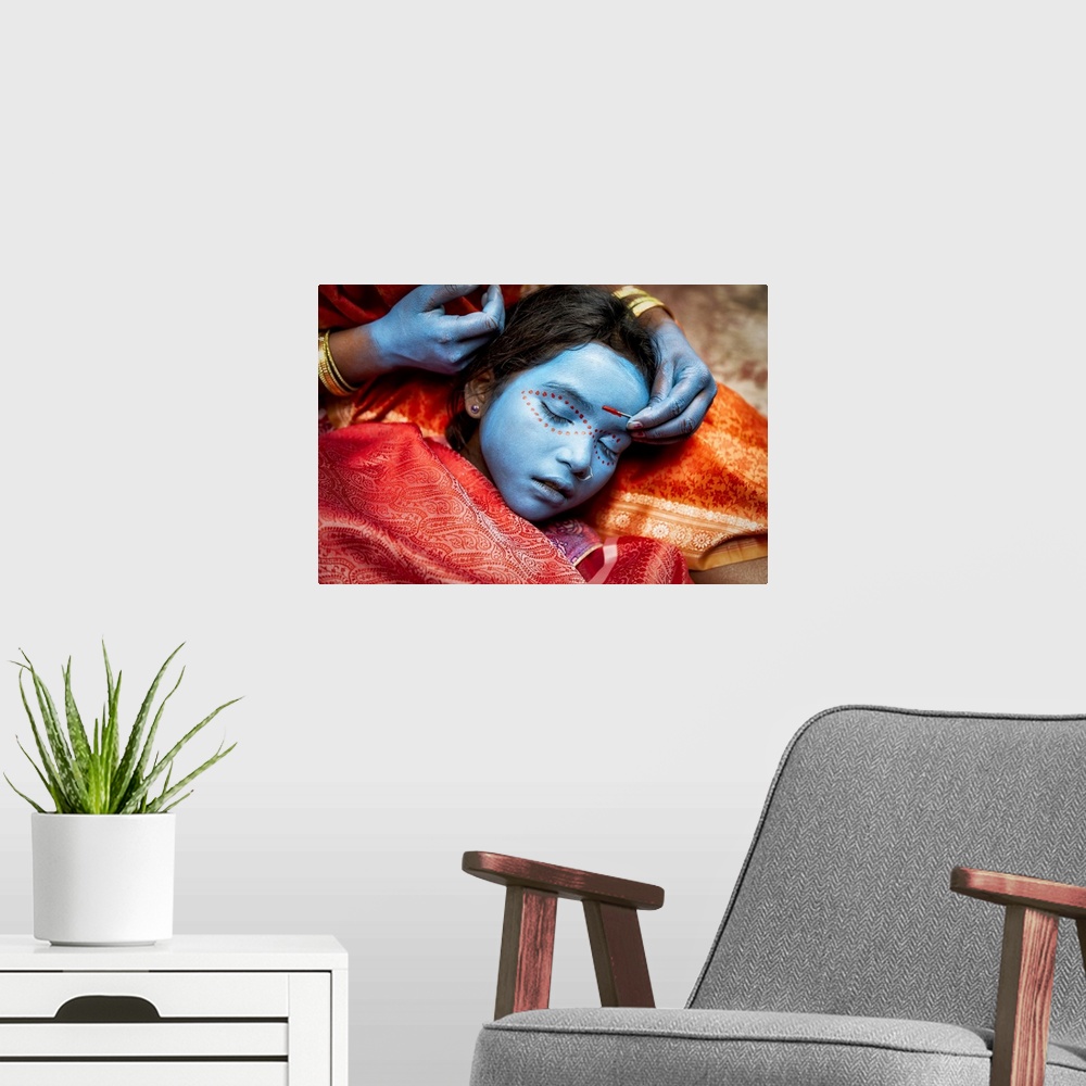 A modern room featuring Young girl having her face painted in Varinasi, India