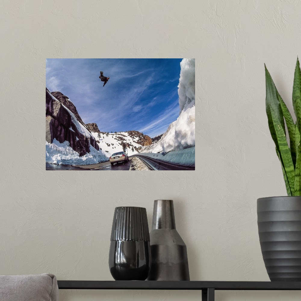 A modern room featuring Nate Mott flying on his snowboard over the Donner Summit, as a car passes by below, California, m...