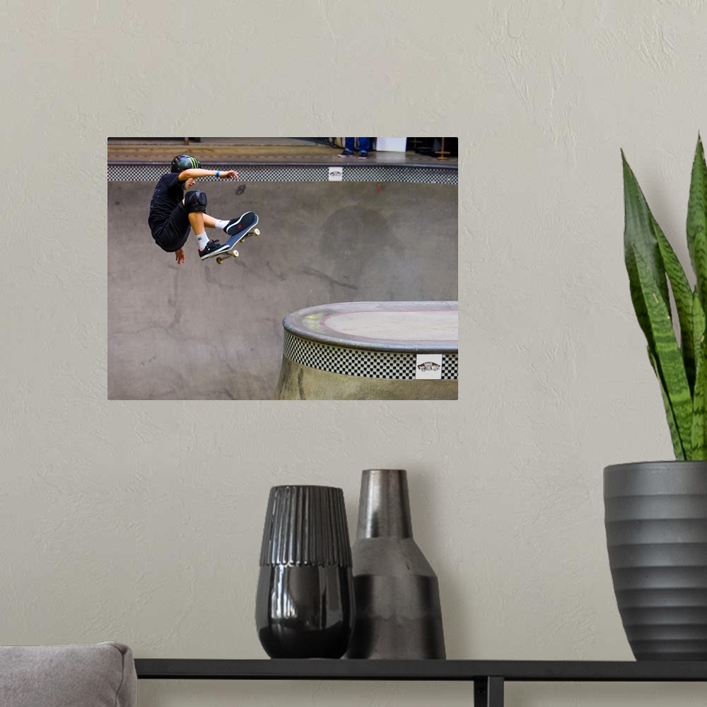 A modern room featuring Tom Schaar jumping on his skateboard at Vans Off The Wall Skatepark in Huntington Beach, Californ...