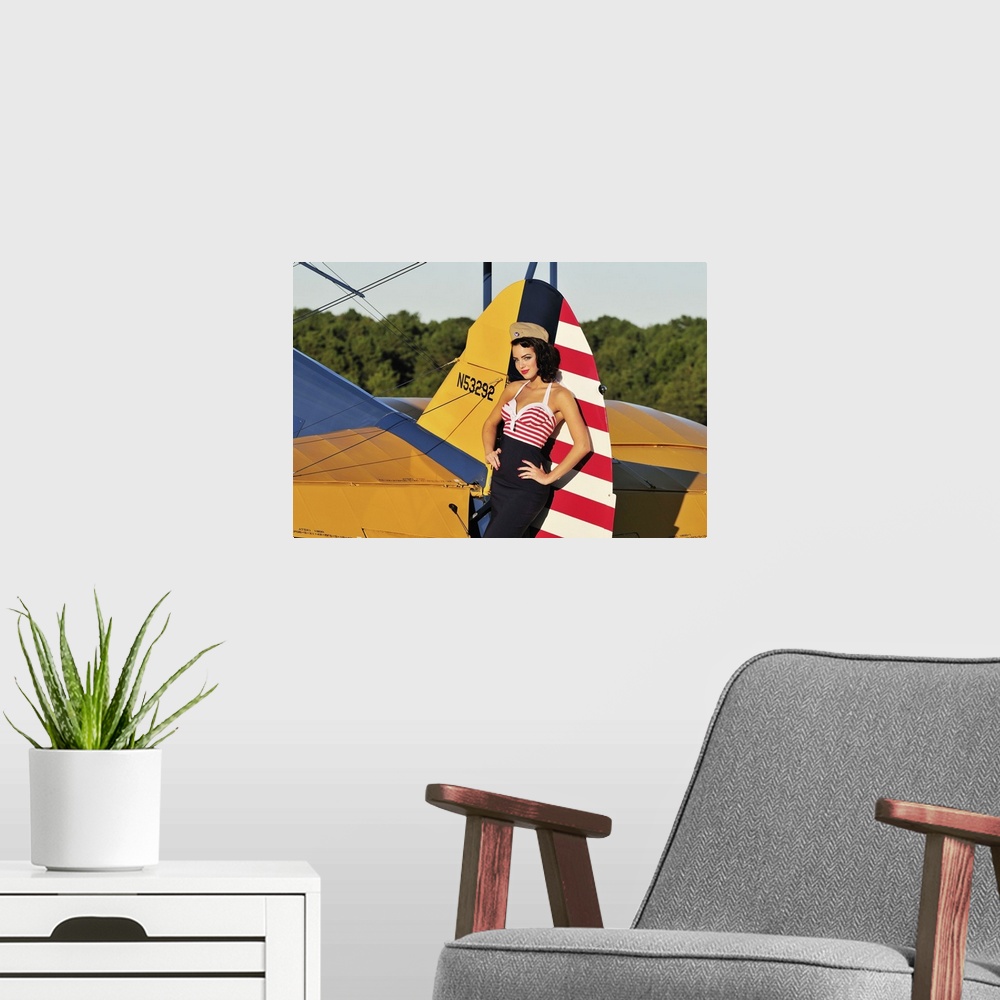 A modern room featuring Patriotic 1940's style pin-up girl leaning on the tail fin of a World War II Stearman biplane.