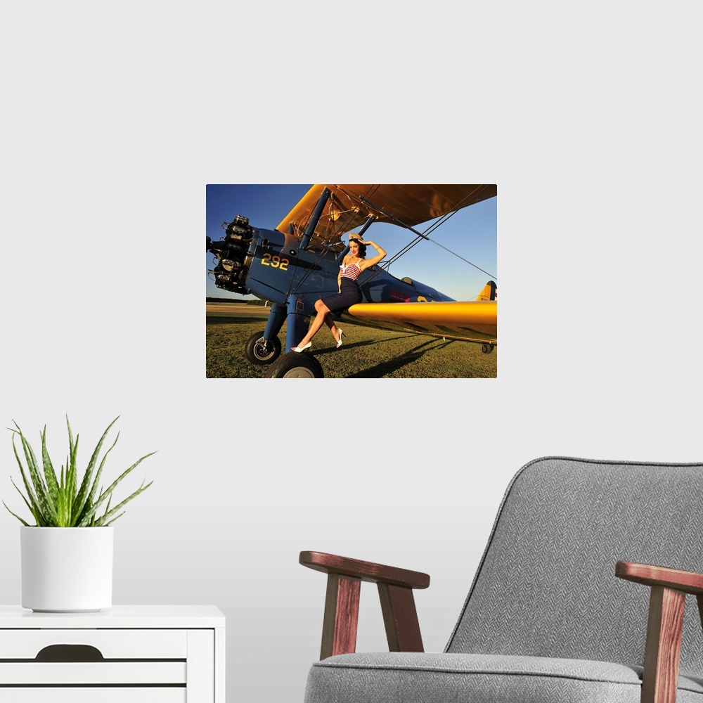 A modern room featuring Patriotic 1940's style pin-up girl sitting on the wing of a World War II Stearman biplane.