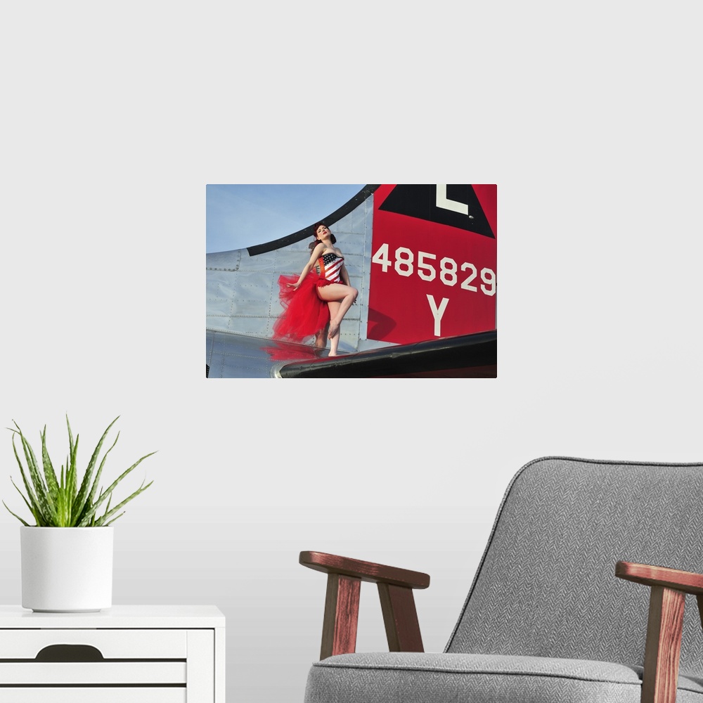 A modern room featuring Beautiful 1940's style pin-up girl standing on the tail of a B-17 bomber.