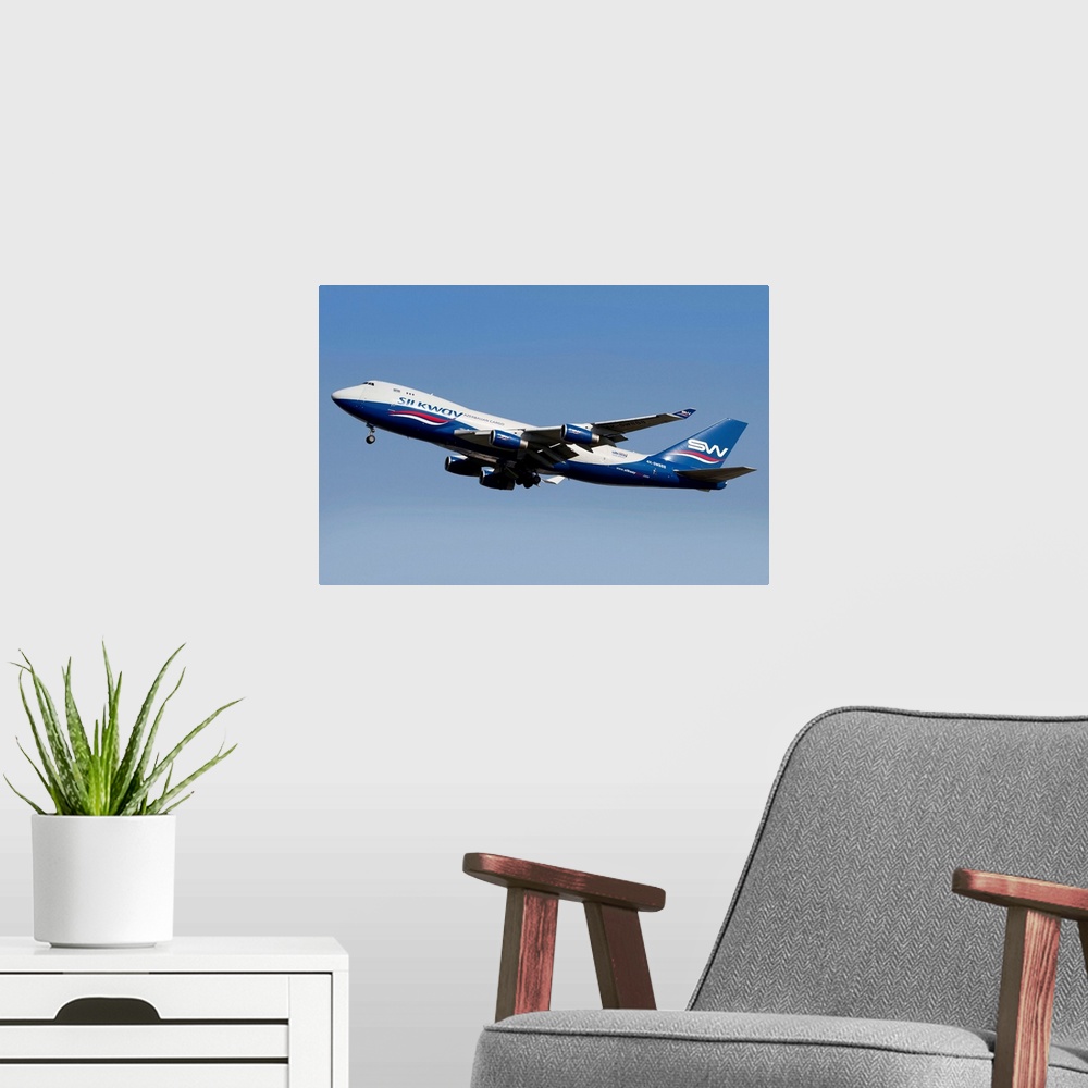 A modern room featuring A Boeing 747-400 of Slik Way Airlines in flight over Italy.