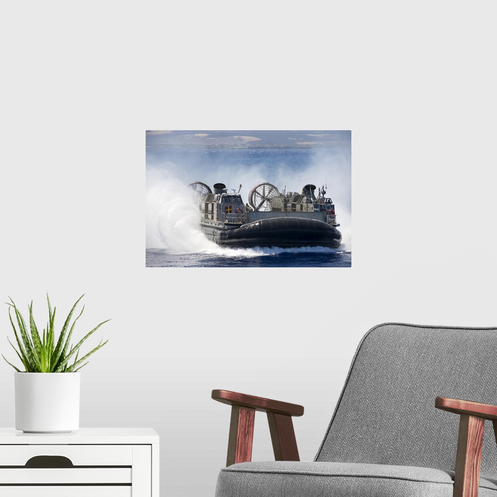A modern room featuring Pacific Ocean, July 23, 2014 - A landing craft air cushion prepares to embark the well deck of th...