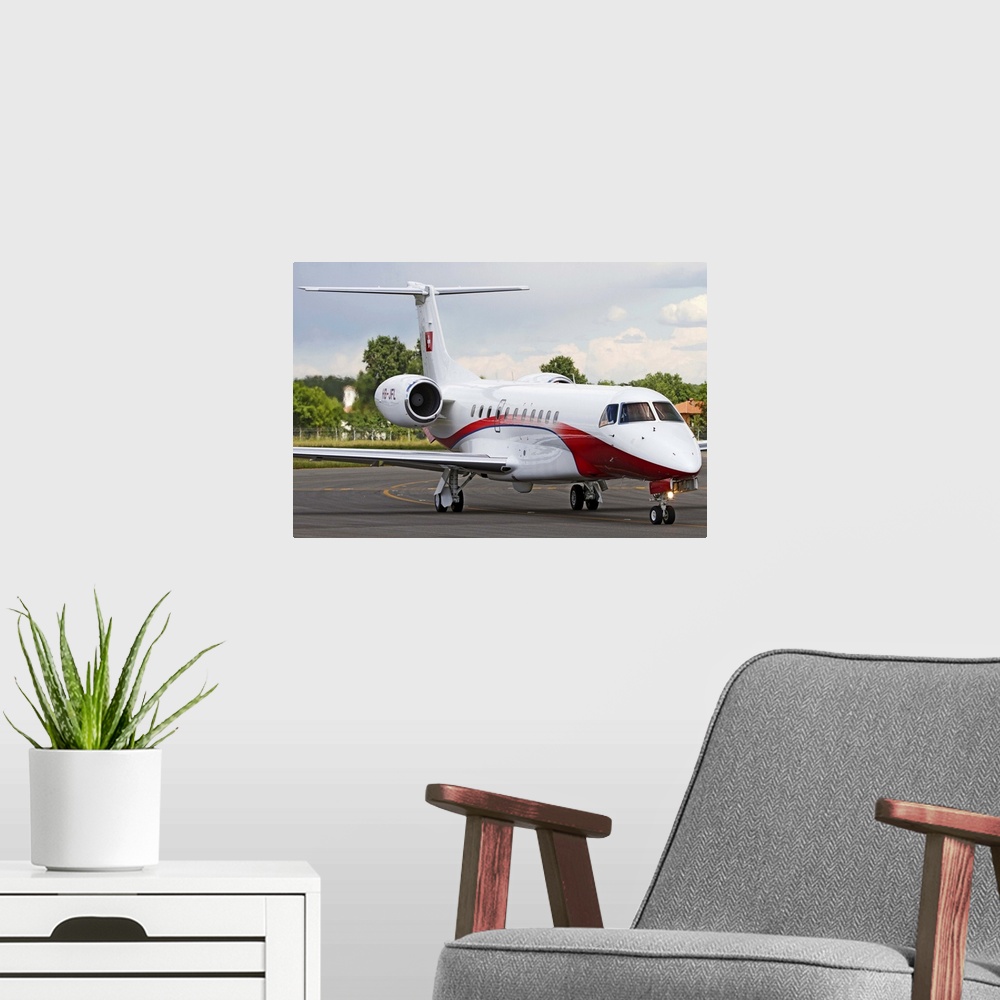 A modern room featuring An Embraer Legacy 600 private jet taxiing at Turin Airport, Italy.