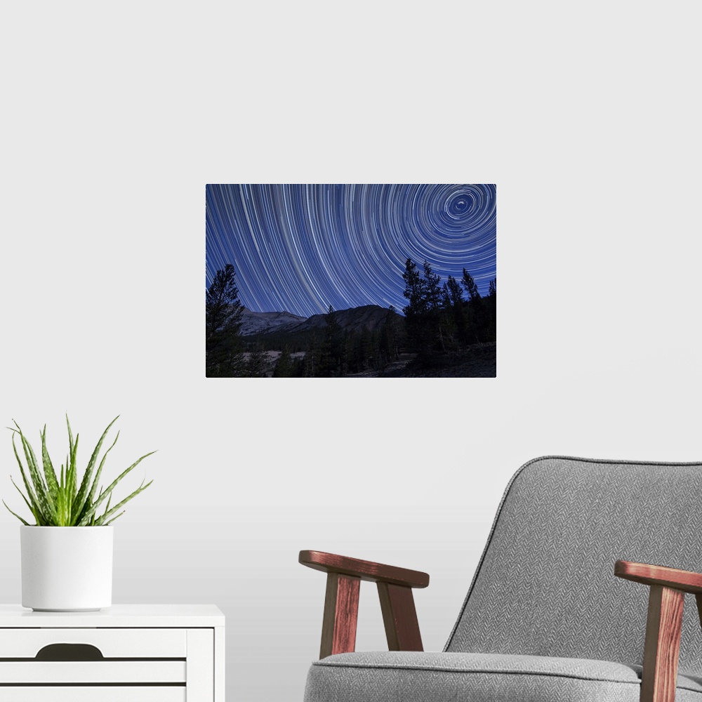 A modern room featuring Star trails above mountain peaks in the high sierras near Yosemite National Park, California.