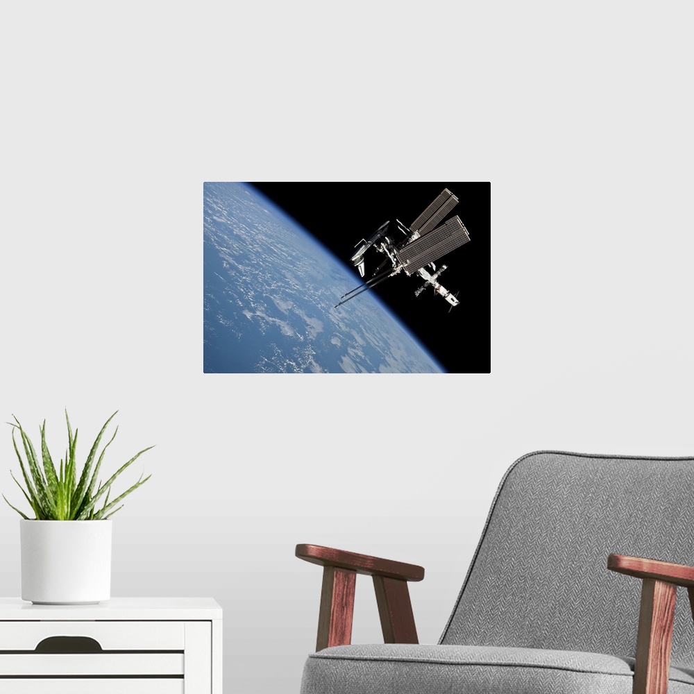 A modern room featuring May 23, 2011 - The International Space Station and docked Space Shuttle Endeavour, backdropped by...