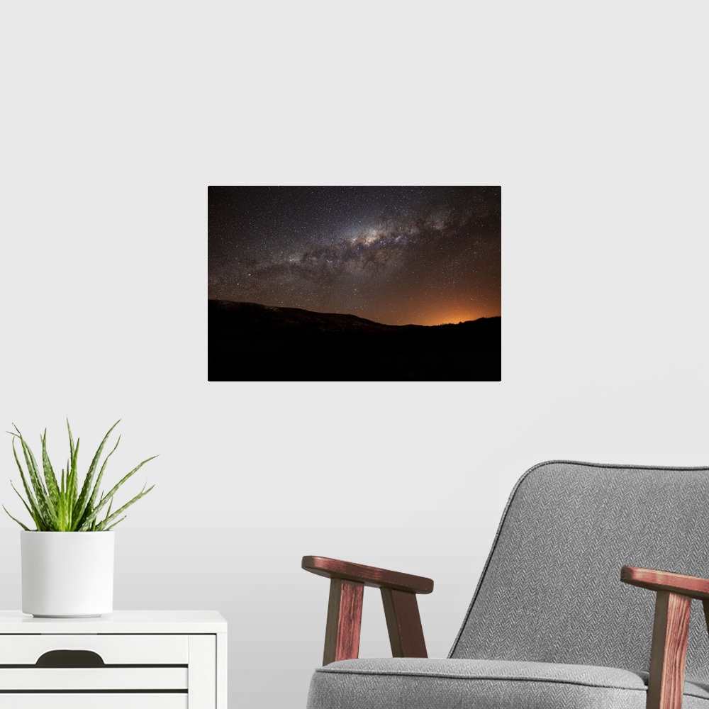 A modern room featuring The Milky Way setting behind the hills of Azul, Argentina, part of the Tandilia Hills. The light ...